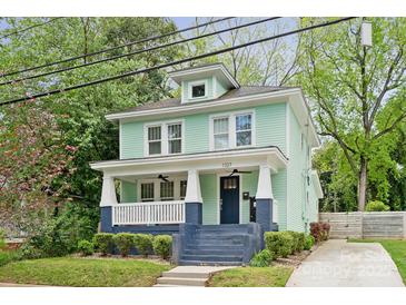 Charming two-story home with a covered front porch, painted in a refreshing light green with blue trim at 1327 Fairmont St, Charlotte, NC 28216