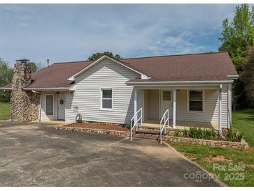 Charming single-Gathering home featuring a stone chimney, covered porch, and white vinyl siding at 1501 Nc Hwy 73 Hwy, Iron Station, NC 28080