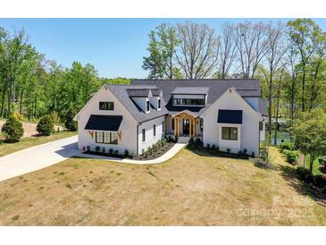 Stunning modern farmhouse featuring black window frames, black awnings and meticulous landscaping at 153 High Hills Dr, Mooresville, NC 28117