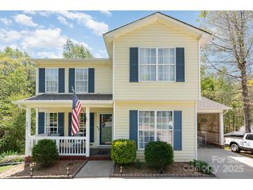 Charming two-story home with a welcoming front porch and beautiful, lush landscaping at 201 Olde Coach Ln, Crouse, NC 28033