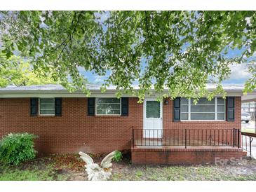 Charming brick home featuring a covered front porch and mature trees at 2218 W Fifth Ave, Gastonia, NC 28052