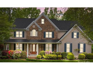 Charming two-story home with stone facade, lush landscaping, and a welcoming front porch at 263 Fernbrook Dr, Mooresville, NC 28117