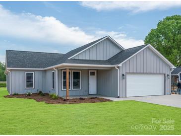 Charming single-story home features a gray exterior, a well-maintained lawn, and an attached garage at 28655-A Nc Hwy 73 Hwy, Albemarle, NC 28001
