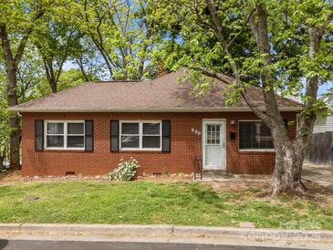 Charming brick home featuring a well-maintained lawn, mature trees, and a welcoming front entrance at 330 Clover St, Mooresville, NC 28115