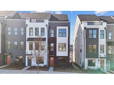 Modern townhome featuring a sleek brick and siding exterior with large windows and a pop of color from the front door at 433 Blairhill Rd # 08, Charlotte, NC 28217