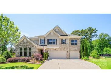 Beautiful two-story home featuring manicured landscaping, a two-car garage, and neutral brick facade at 5028 Whitemarsh Ct, Indian Land, SC 29720