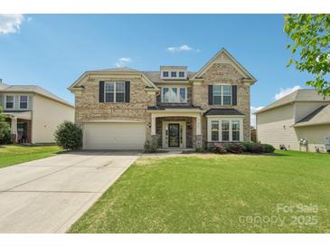 Charming two-story brick home with a well-manicured lawn and attached two-car garage at 5037 Nighthawk Dr, Fort Mill, SC 29707