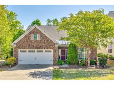 Charming brick home featuring a two-car garage, landscaped yard, and a welcoming entrance with decorative shutters at 5050 Kinross Ln, Indian Land, SC 29707
