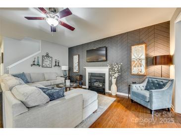 Comfortable living room featuring a fireplace, ceiling fan, and stylish decor at 5050 Kinross Ln, Indian Land, SC 29707