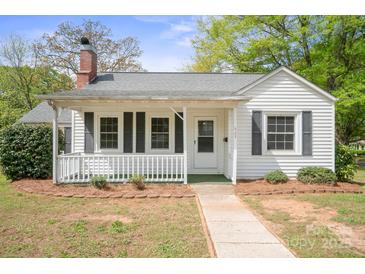 Charming single-story home featuring a welcoming front porch, classic white siding, and a well-maintained landscaped front yard at 627 N Flint St, Lincolnton, NC 28092