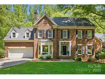 Charming two-story brick home with manicured lawn and mature trees, showcasing classic architectural details at 902 Hoke Trl, Cramerton, NC 28032