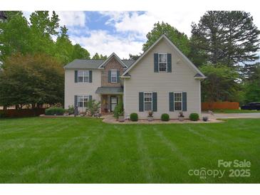 Charming two-story home with green shutters, manicured lawn, and beautiful landscaping at 9106 Dogwood Ridge Dr, Charlotte, NC 28227