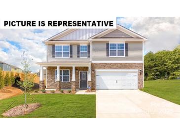 Charming two-story home featuring a stone-accented facade, a two-car garage, and a well-maintained lawn at 103 Way Cross Ln, Troutman, NC 28166