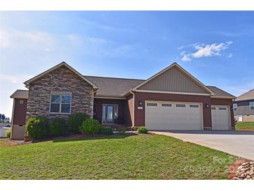Beautiful home featuring a stone facade, three-car garage, and well-maintained lawn, offering curb appeal and space at 164 Castle Pines Ln, Statesville, NC 28625