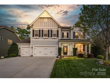 Charming two-story home with a three-car garage and well-manicured lawn and front garden at 2002 Thurston Dr, Indian Trail, NC 28079