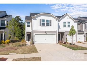 Inviting two-story townhome with a white garage door, gray accents, and a well-maintained front yard at 2340 Belterra Dr, Charlotte, NC 28216