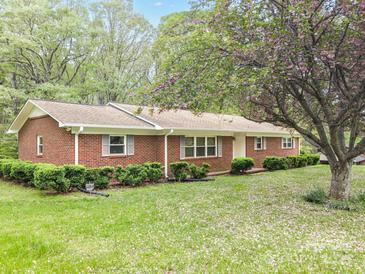 Charming red brick home with mature landscaping and a blooming tree in the front yard at 2582 Ivey Church Rd, Lincolnton, NC 28092