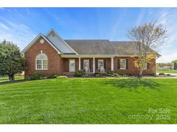 Charming brick home with a well-manicured lawn, rocking chairs on the front porch, and classic architectural details at 2610 Flagstone Ct, Shelby, NC 28152