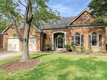 Charming brick home featuring manicured lawn, arched entry, and two car garage at 3017 Planters Walk Ct, Charlotte, NC 28210