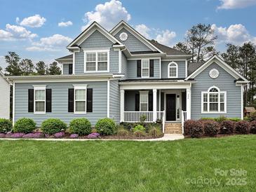 Charming two-story home features a well-manicured lawn and inviting front porch at 358 Hampton Trail Dr, Fort Mill, SC 29708