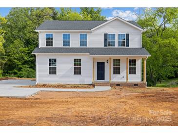 Charming two-story home featuring a welcoming front porch and freshly landscaped yard on a sunny day at 4175 River Run Cir, Hickory, NC 28602
