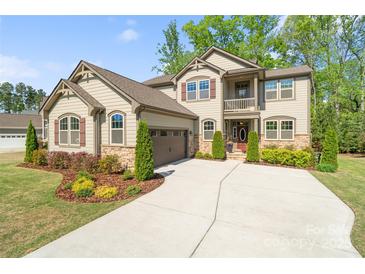 Charming two-story home featuring a manicured lawn, stone accents, and attached two car garage at 513 Sandbar Pt, Lake Wylie, SC 29710