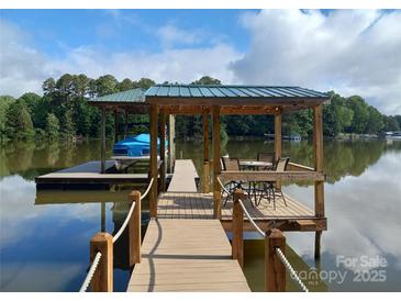 Beautiful dock featuring a boat slip, covered seating area, and stunning lake views perfect for relaxation and entertainment at 6778 Emerald Isle Dr, Sherrills Ford, NC 28673
