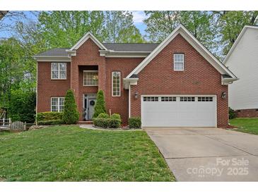 Beautiful two-story brick home with well-manicured lawn and attached two-car garage at 8600 Glade Ct, Huntersville, NC 28078