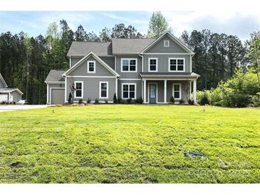 Large, gray two-story home with lush green lawn and meticulously landscaped front yard at 117 Blackbeard Ln, Mooresville, NC 28117