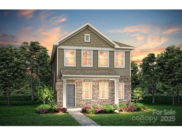 Charming two-story home with stone accents, manicured lawn, and inviting landscaping at 14032 Penbury Ln # 332, Charlotte, NC 28273