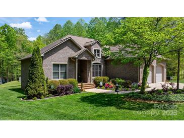 Charming single-Gathering home featuring a brick exterior, well-manicured lawn, and lush landscaping at 1590 W 7Th St, Newton, NC 28658