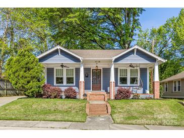 Charming blue home with a quaint front porch, swing, brick accents, and beautiful landscaping at 1716 Wickford Pl, Charlotte, NC 28203