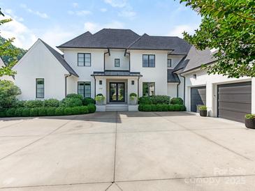 Stunning white brick two-story home with a black roof, manicured landscaping, and a spacious concrete driveway at 2343 Vernon Dr, Charlotte, NC 28211