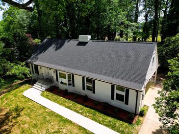 Beautifully renovated home featuring a classic white exterior, black shutters, and a well-manicured lawn at 2601 Pinewood Rd, Gastonia, NC 28054
