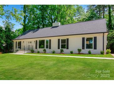 Charming home featuring a classic white brick exterior, black shutters, and a lush green lawn at 2601 Pinewood Rd, Gastonia, NC 28054