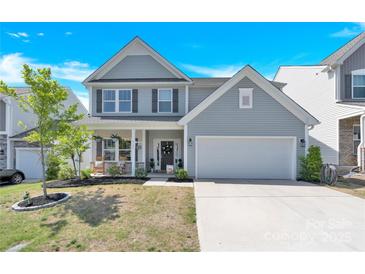 Charming two-story home with a well-manicured lawn and inviting two-car garage at 3153 Pinehills Way, Mount Holly, NC 28120