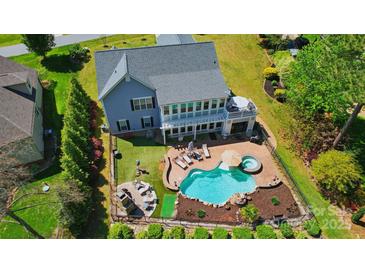 Aerial view of a beautiful backyard with a pool, hot tub, outdoor kitchen, and lounge area for entertaining at 4160 Isle Of Pines Dr, Denver, NC 28037