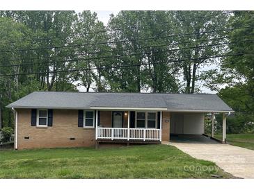 Charming brick home with a covered porch and carport, nestled amongst mature trees at 609 E Maine Ave, Bessemer City, NC 28016