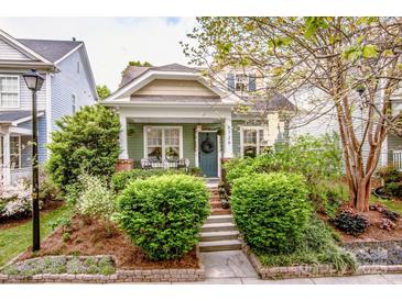 Charming home with lush landscaping and a welcoming front porch with dark green door and symmetrical shrubbery at 6726 Park Meadows Pl, Huntersville, NC 28078