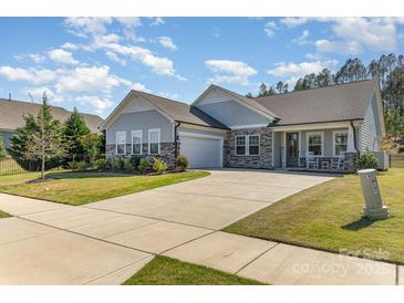 Charming single Gathering home with a long driveway, attached garage, and covered front porch with rocking chairs at 8011 Green Heron Ct, Belmont, NC 28012
