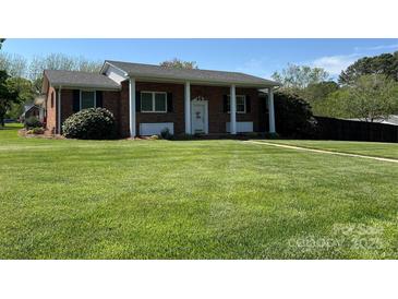 Charming brick home with a manicured lawn and white pillars accenting the front entrance at 901 Ridge St, Albemarle, NC 28001