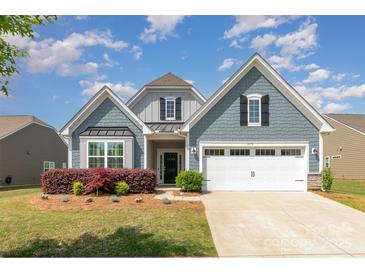 Charming two-story home with a manicured lawn, a two-car garage, and blue shingle siding at 1670 Tranquility Blvd, Lancaster, SC 29720