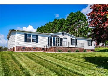Charming single-story home featuring tidy landscaping, brick foundation and neutral siding and black shutters at 186 Ellendale Ln, Taylorsville, NC 28681