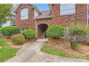 Charming brick condo building featuring an arched entryway and well-manicured landscaping at 2515 Carya Pond Ln, Charlotte, NC 28212