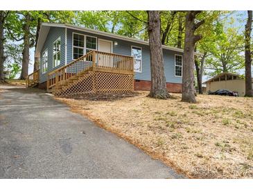 Charming single-story home features a new front porch, blue siding, and mature trees, offering a peaceful setting at 313 Villa St, Kannapolis, NC 28083