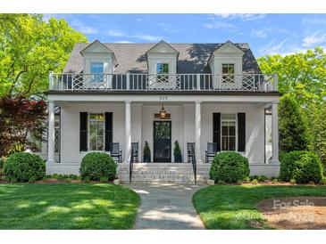 Charming two-story white brick home with a welcoming front porch and manicured lawn at 503 Walnut St, Davidson, NC 28036