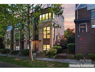 Charming townhome featuring a brick facade, manicured landscaping, and large windows at 656 Garden District Dr, Charlotte, NC 28202
