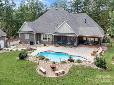 A backyard featuring a swimming pool, fire pit and covered outdoor seating area at 7181 Windy Ridge Dr, Iron Station, NC 28080