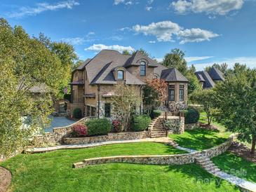 Stunning brick home featuring professional landscaping, stone accents, and a charming stone stairway to the front entrance at 7311 Barrington Ridge Dr, Fort Mill, SC 29707