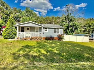 Charming single-story home featuring a welcoming front porch and well-maintained lawn on a sunny day at 9007 Mcmillian Dr, Harrisburg, NC 28075